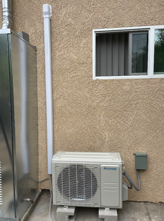 Ductless mini split outdoor unit installed on a home exterior wall
